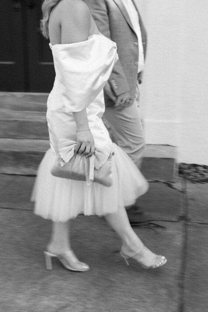 black and white of bride and groom walking