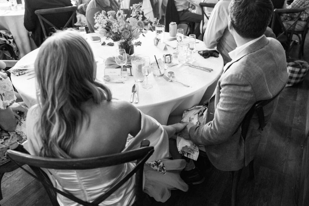 black and white of bride and groom holding hands