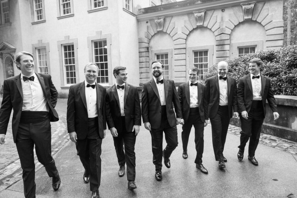 black and white of groomsmen and groom walking at his Swan House Wedding