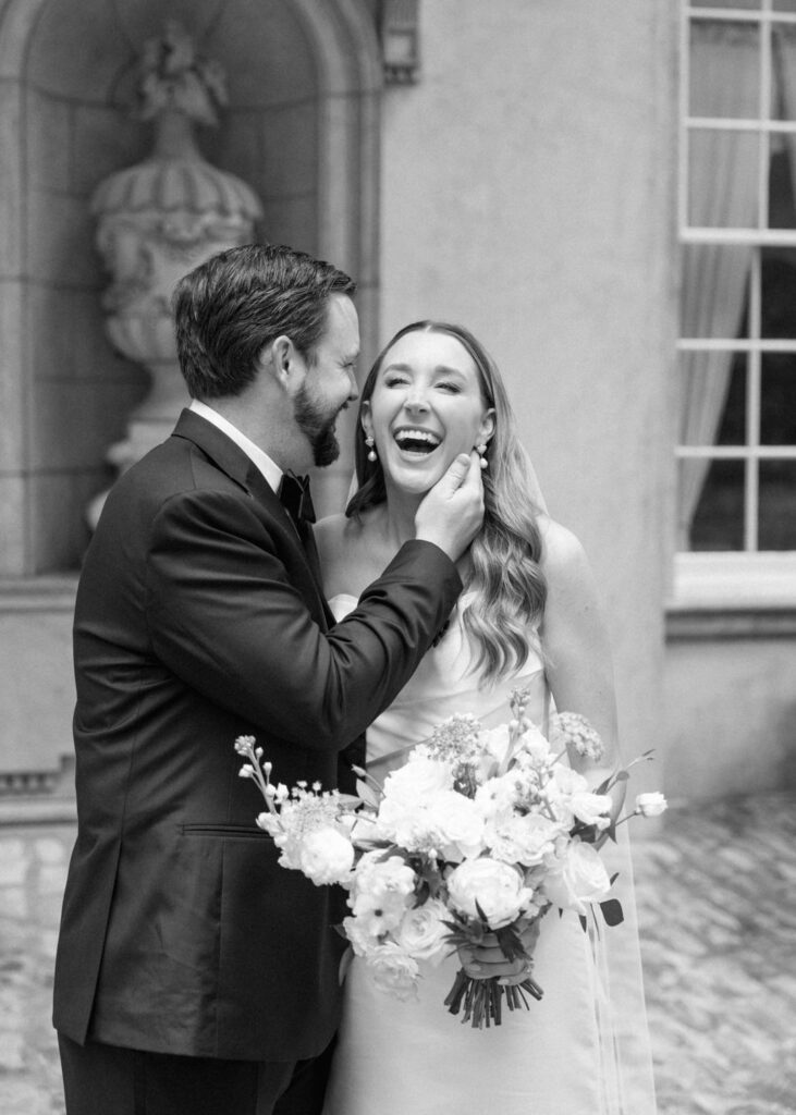 black and white of bride and groom laughing