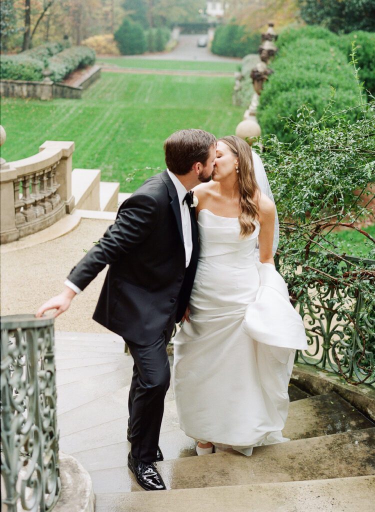 bride and groom kissing on stairs