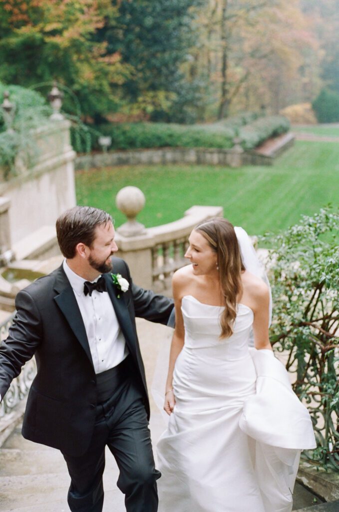 bride and groom smiling walking up stairs