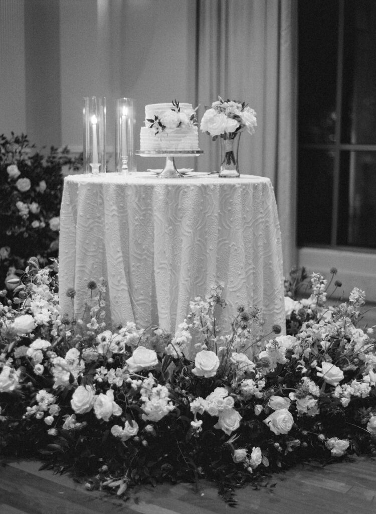 black and white of cake table with flowers