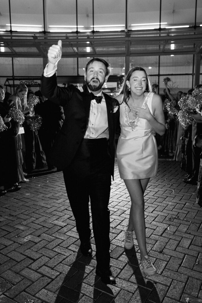 black and white of bride and groom exiting wedding reception