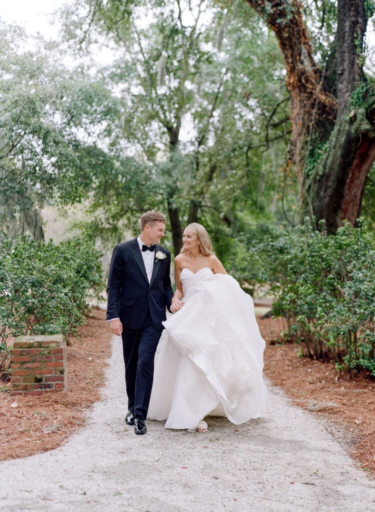 bride and groom holding hands walking toward camera