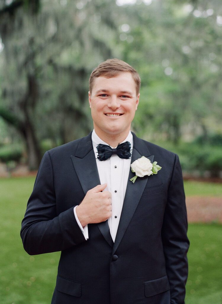 groom holding jacket smiling