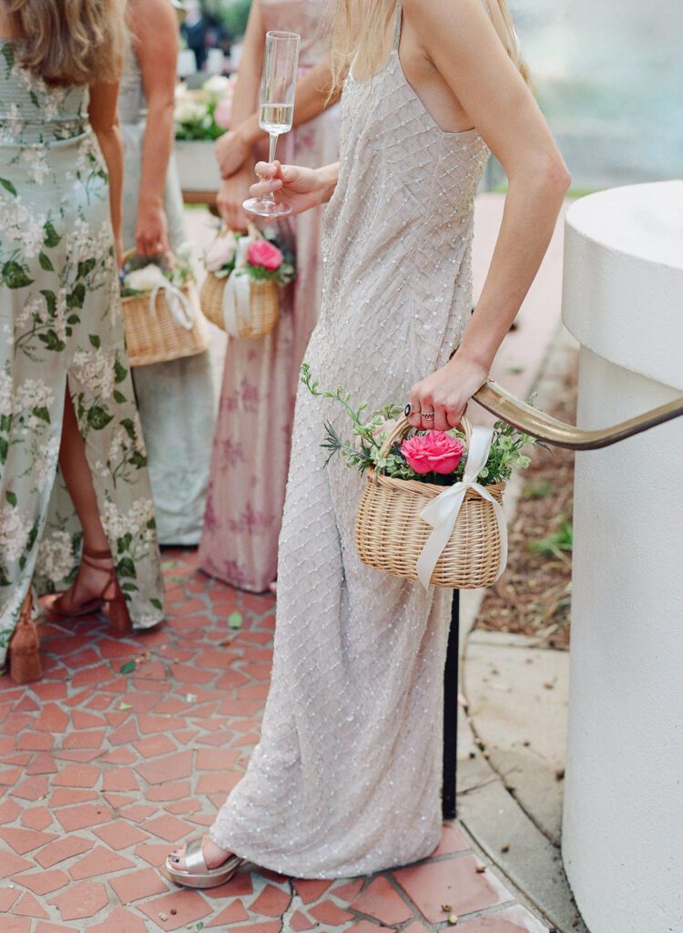 bridesmaid holding basket of flowers and champagne flute