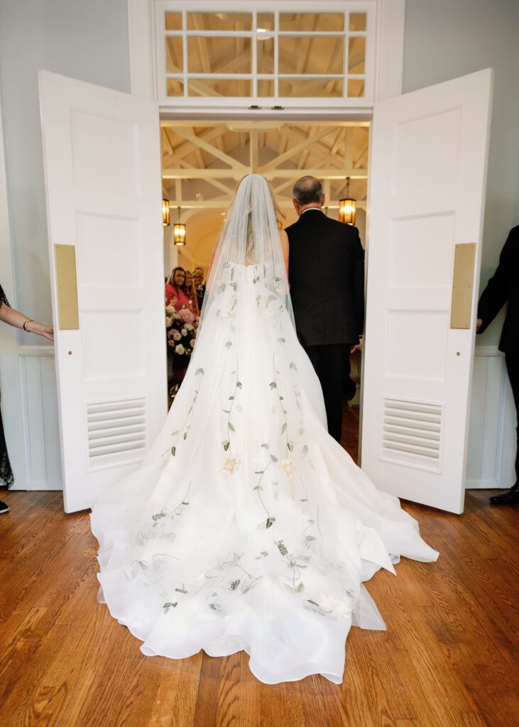 bride and father of the bride walking down ceremony aisle