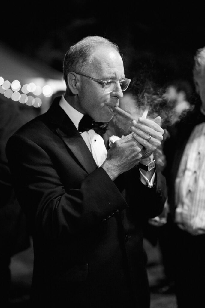 black and white of father of the bride smoking a cigar