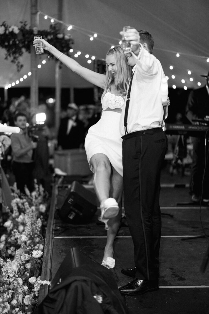 black and white of bride and groom on stage at wedding reception