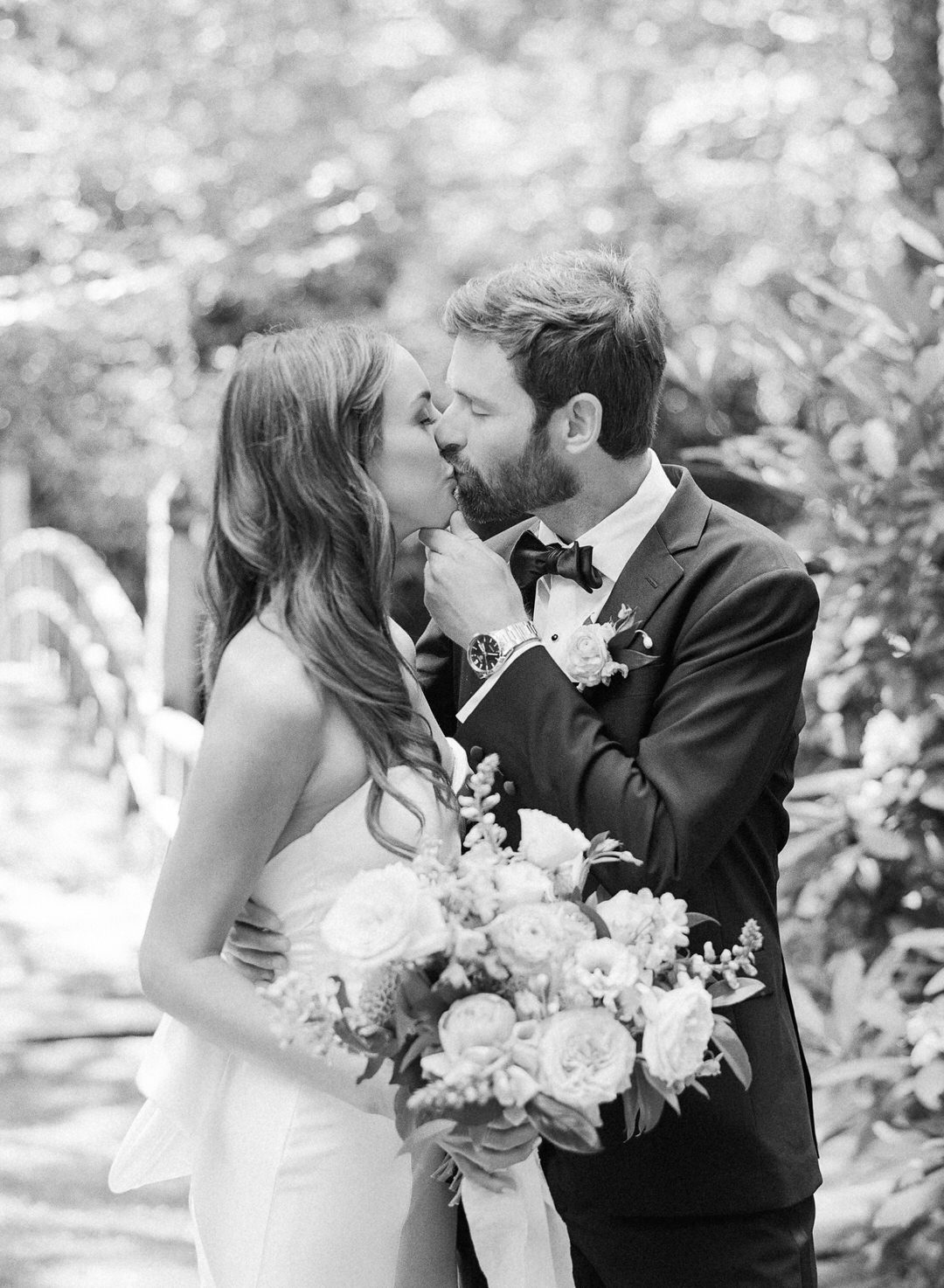 black and white of bride and groom kissing