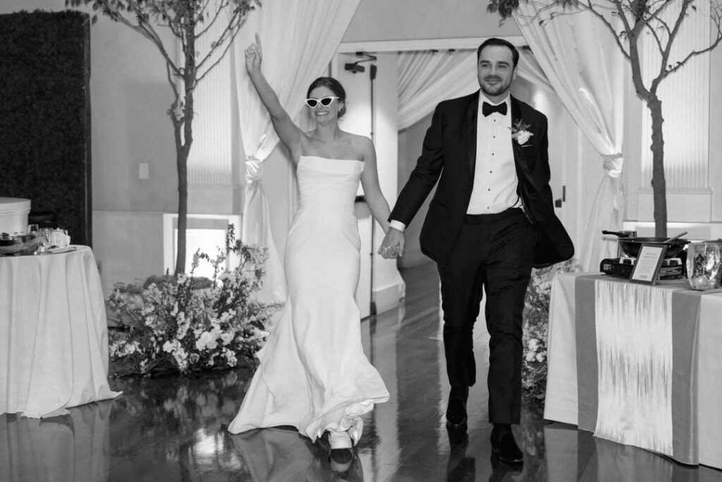 black and white of bride and groom entering wedding reception