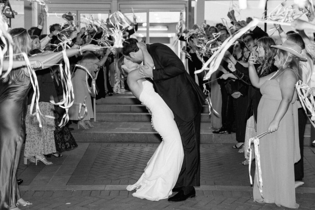 black and white of bride and groom exiting wedding reception