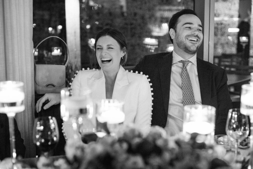 black and white of bride and groom laughing