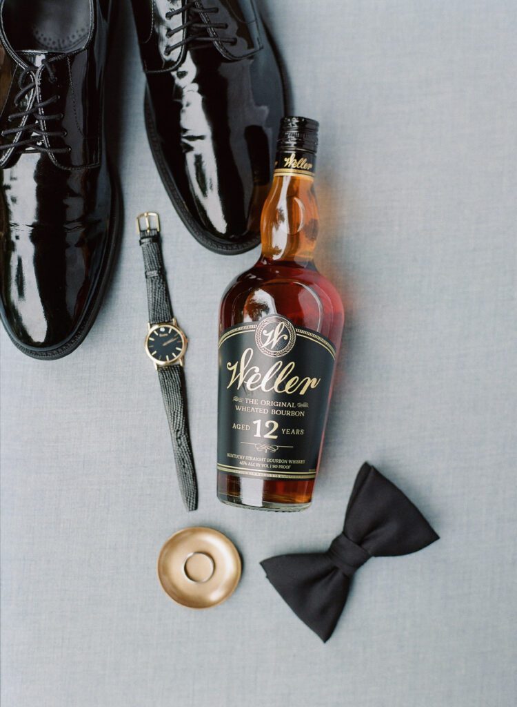 bottle of Weller bourbon groom's watch shoes ring and tie