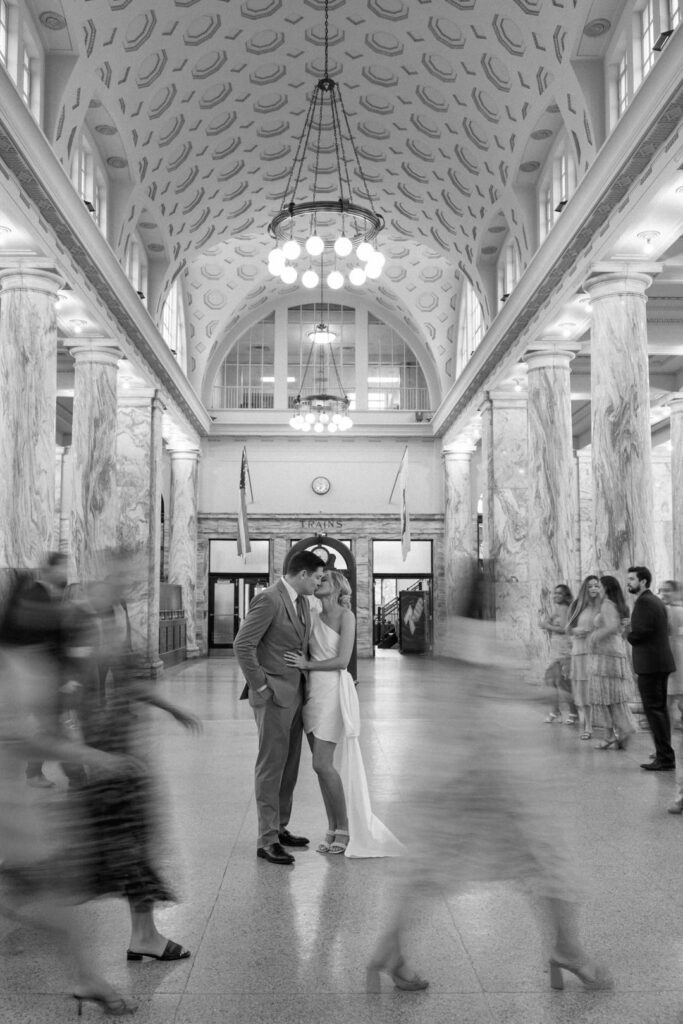 bride and groom in train station kissing