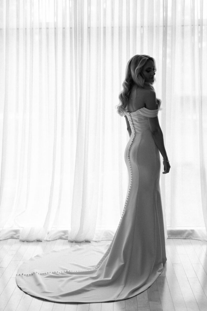 black and white of bride by window