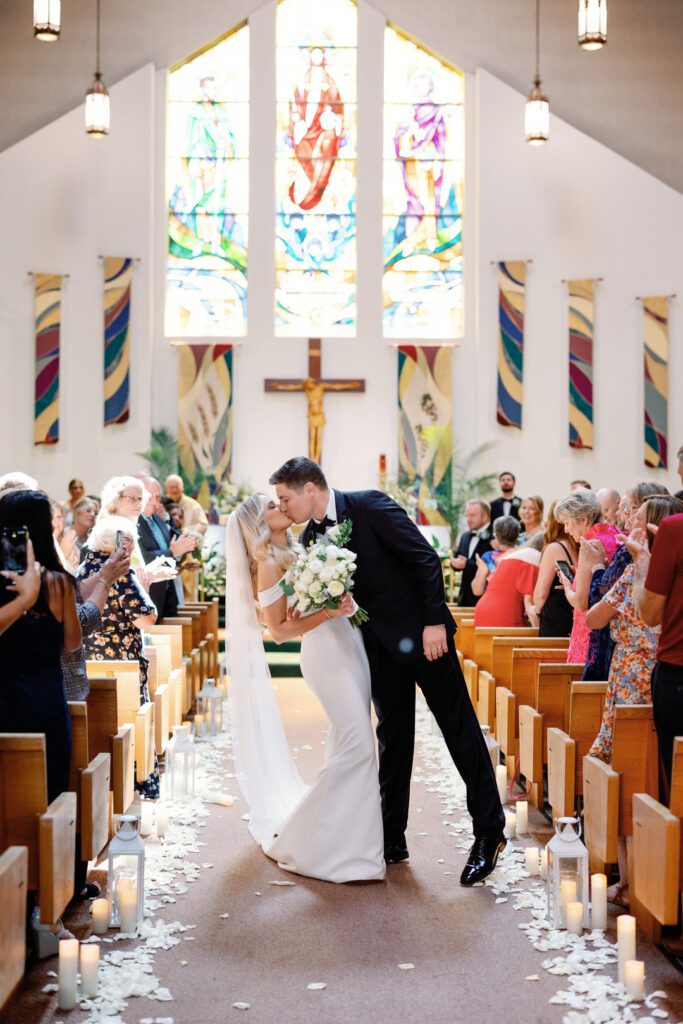 bride and groom kissing ceremony aisle