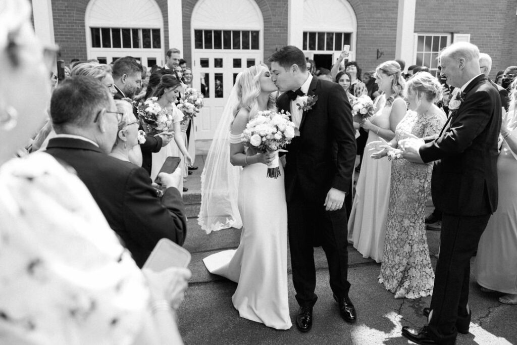 black and white of bride and groom kissing