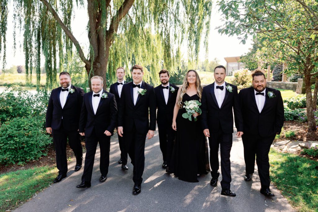 groom walking with groomsmen and grooms woman