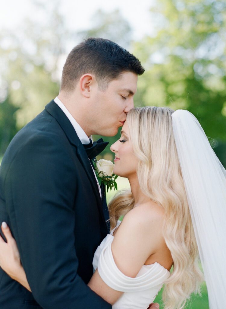 groom kissing bride on forehead