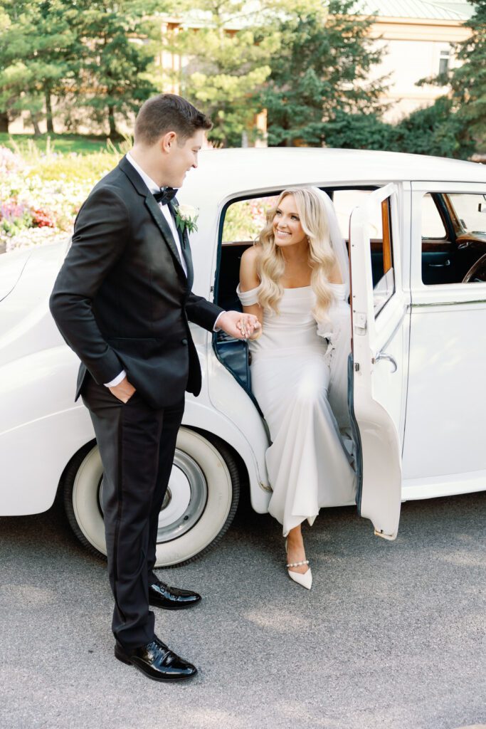 bride and groom stepping out of rolls royce