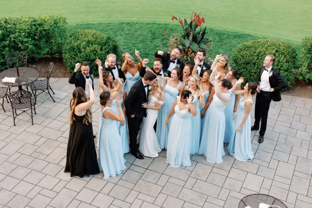 bride and groom kissing groomsmen and bridesmaids cheering