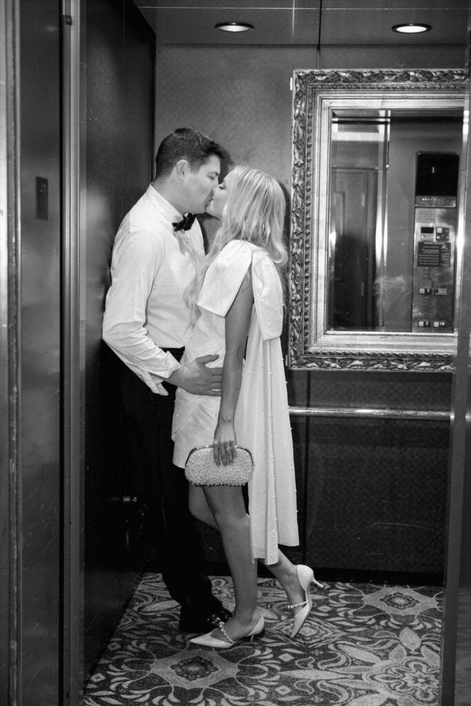 black and white of bride and groom kissing in the elevator