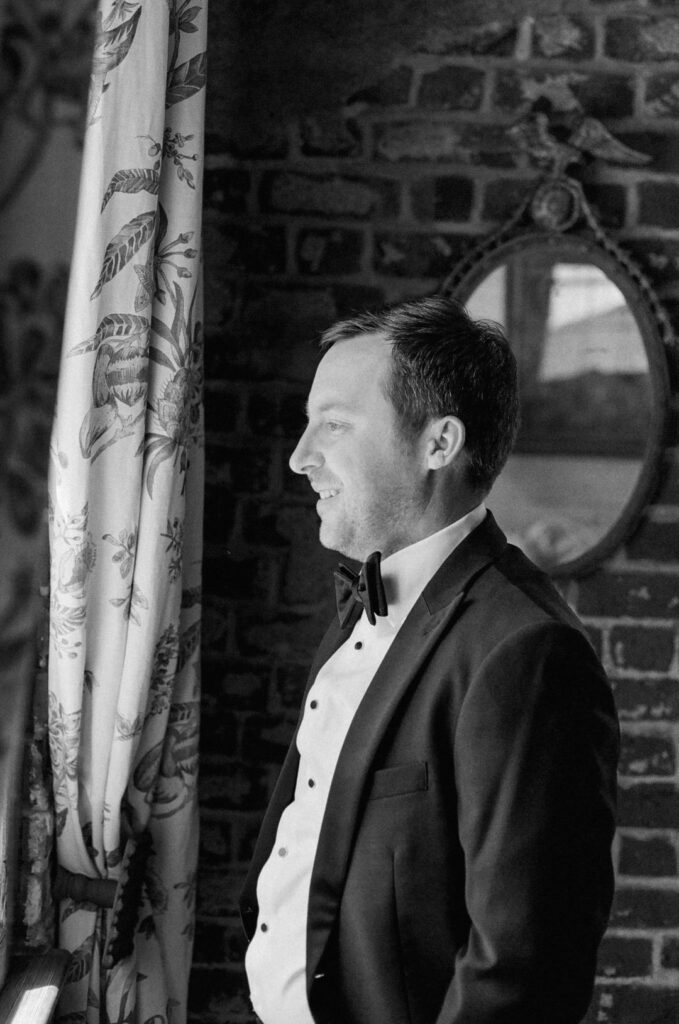 black and white of groom getting ready