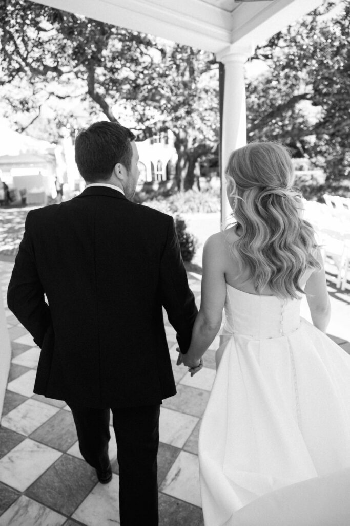 black and white of bride and groom holding hands