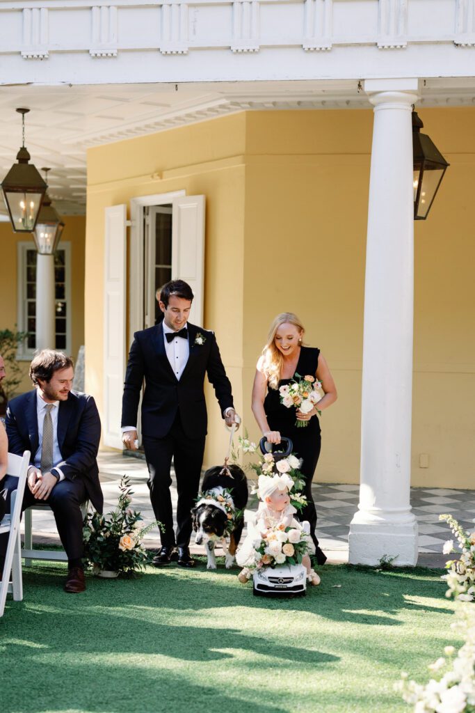 maid of honor and best man walking flower girl and flower dog down aisle