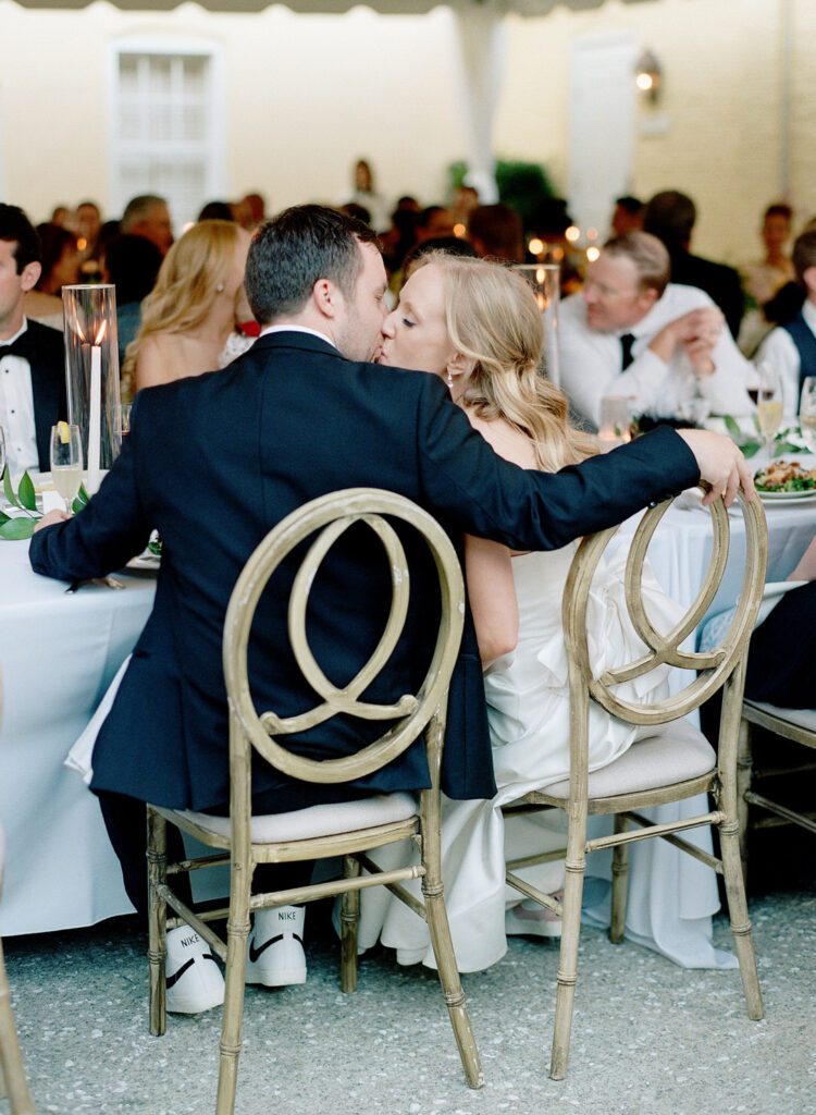 bride and groom kissing at dinner