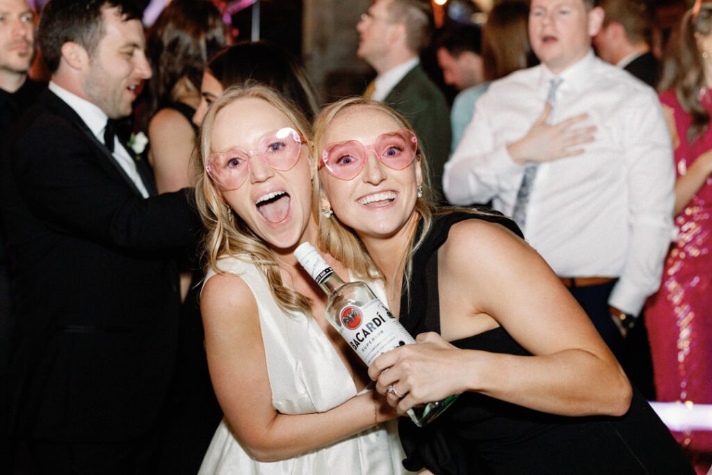 bride and maid of honor with bottle of Bacardi on dance floor