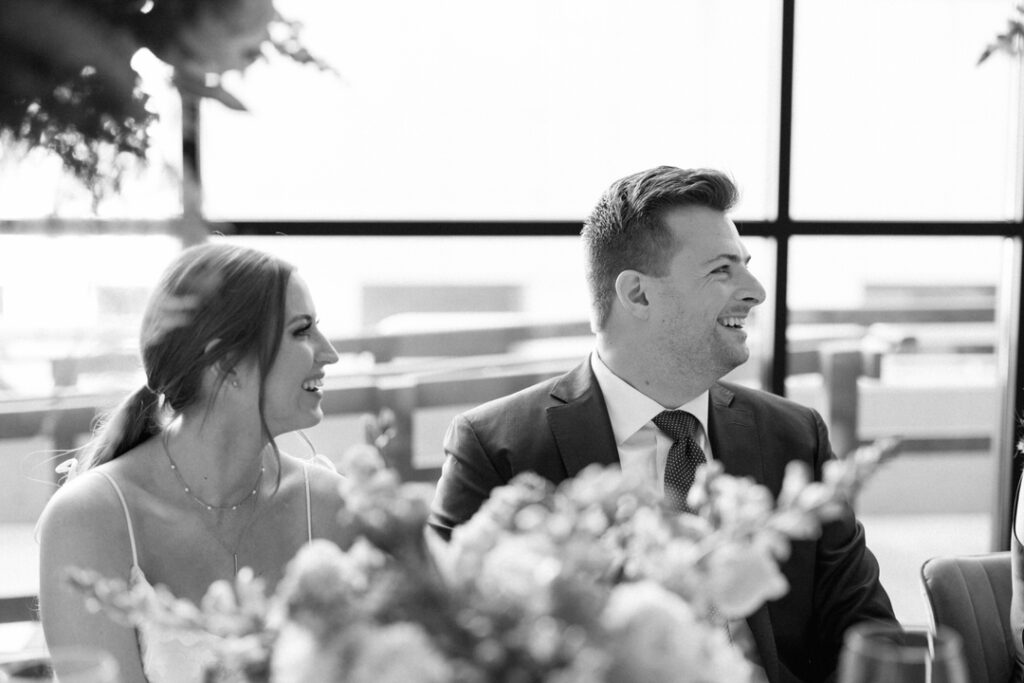 black and white of bride and groom laughing