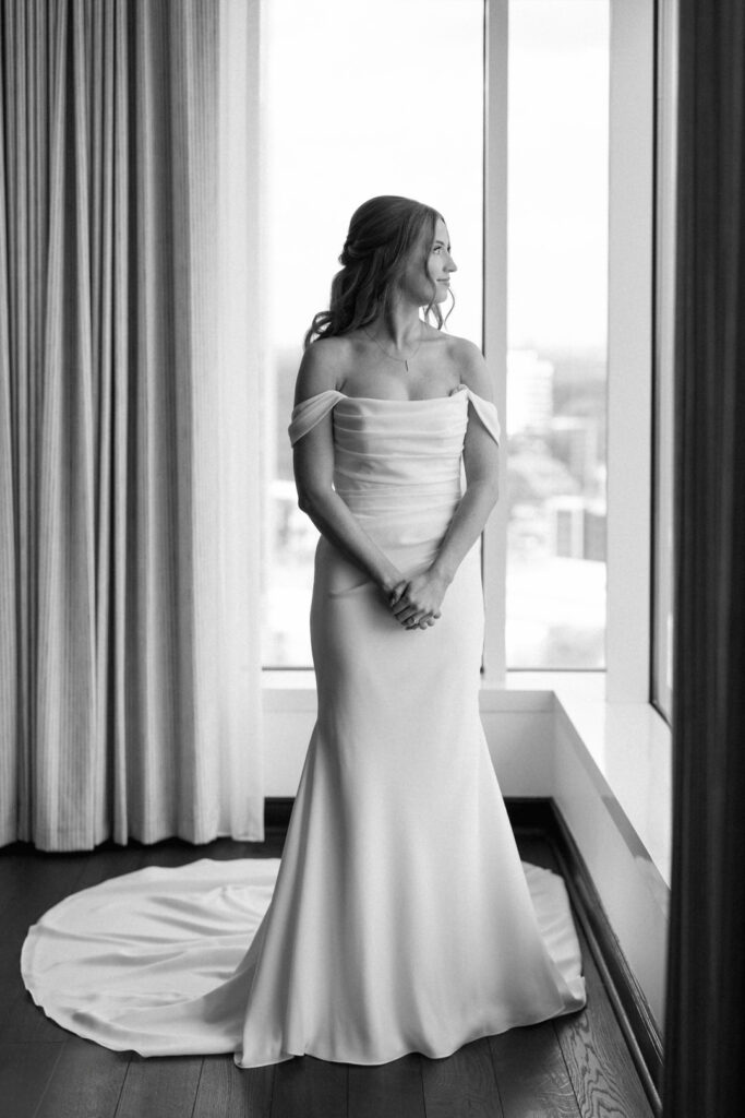 black and white of bride looking out window