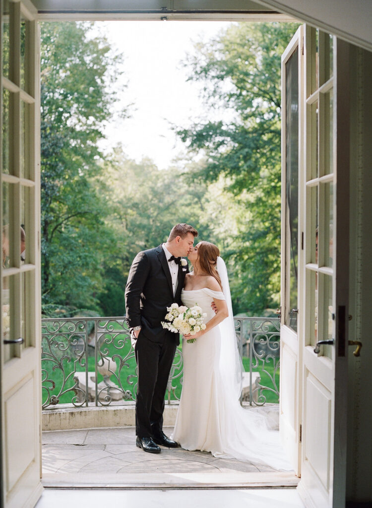 bride and groom kissing on balcony at Swan House Atlanta Georgia