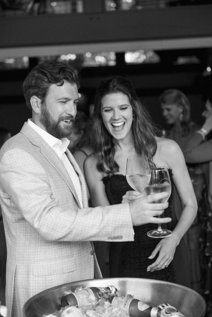 black and white of bride and groom toasting wine glasses