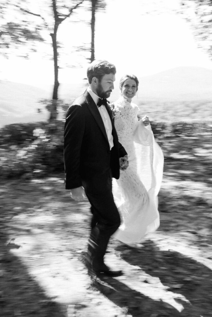 black and white of bride and groom walking