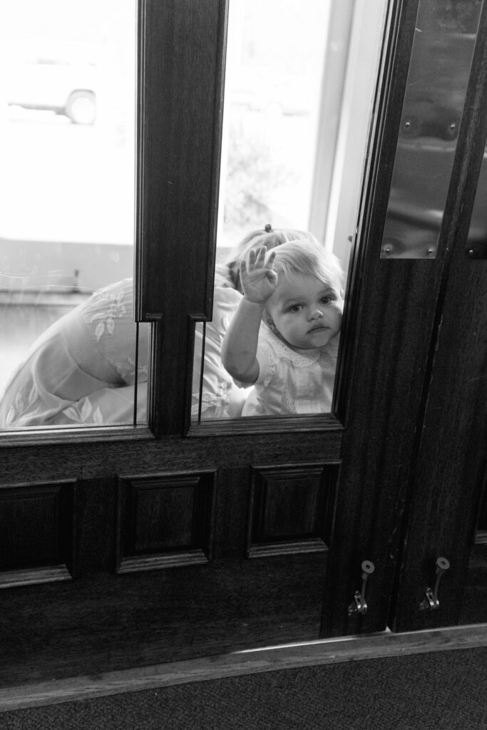 black and white of ring bearer peaking through window