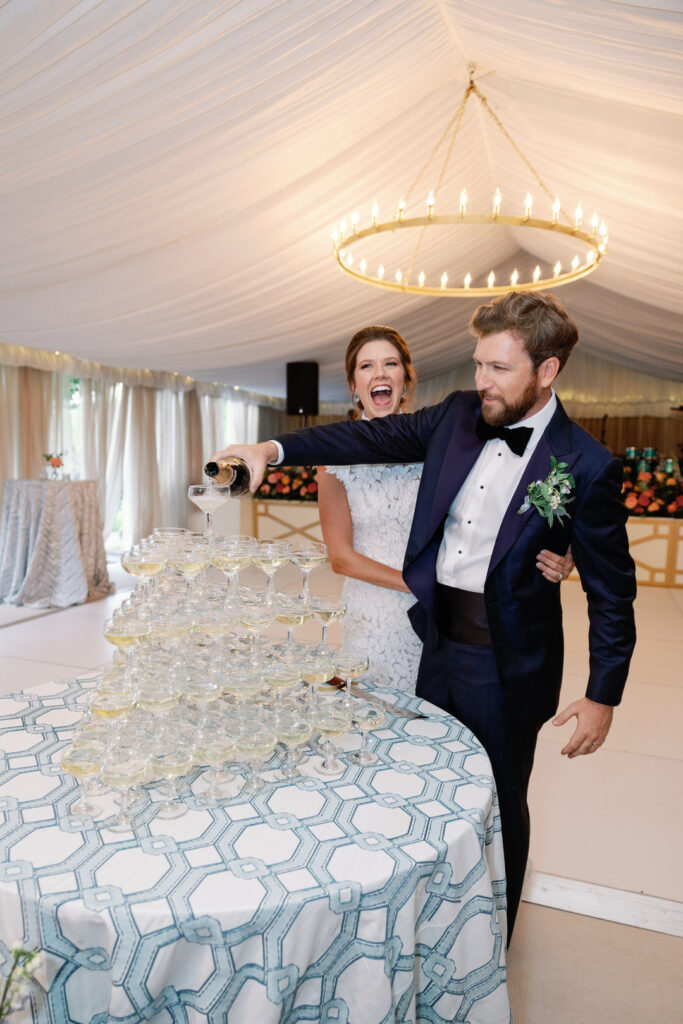 bride and groom pouring champagne in tower