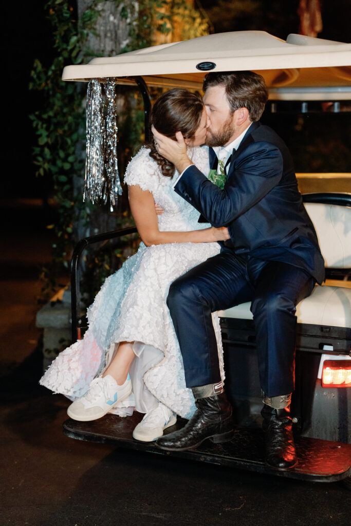 Bride and groom kissing on golf cart