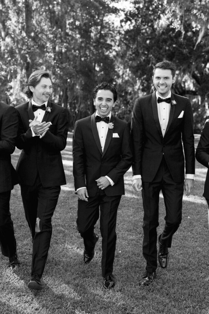 black and white of groom laughing with groomsmen