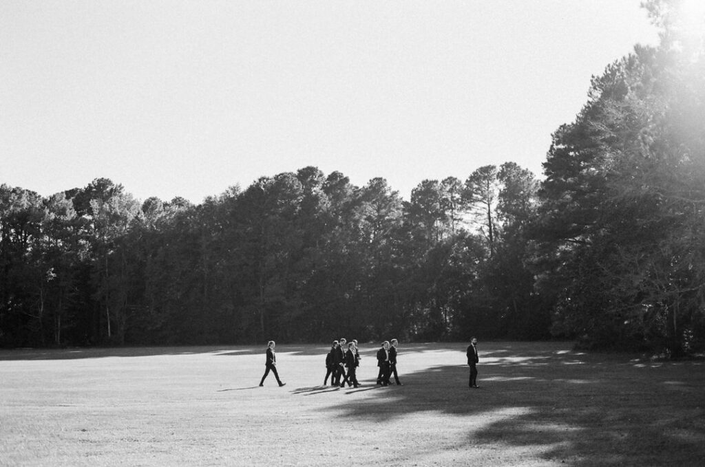 black and white of groomsmen in a field