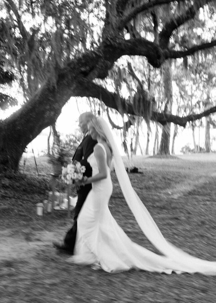 black and white of bride and father of bride walking down aisle