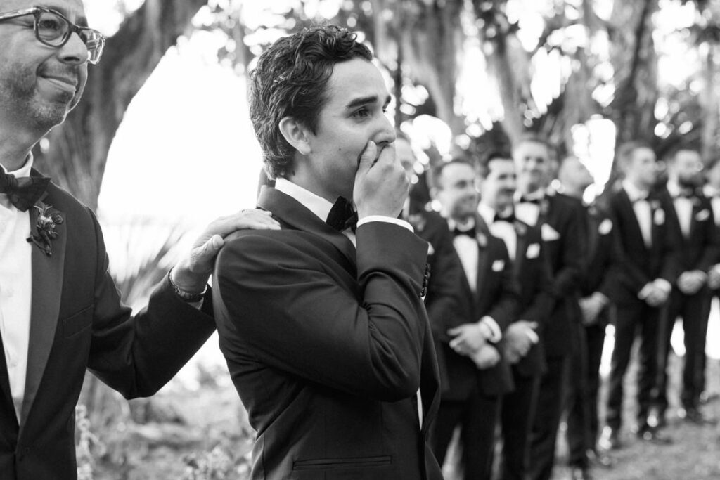 black and white of groom crying when bride comes down the aisle