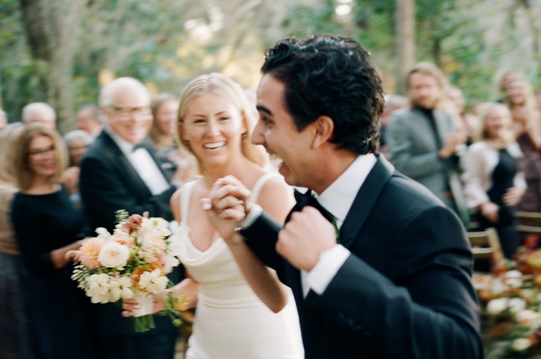 bride and groom smiling exiting ceremony