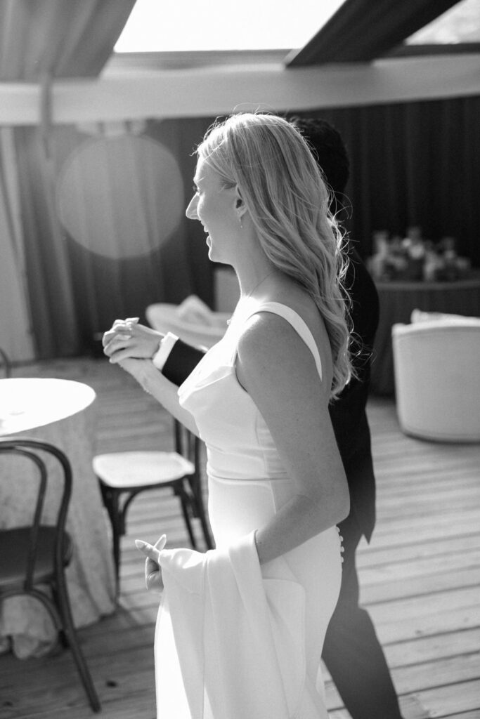 black and white of bride and groom holding hands