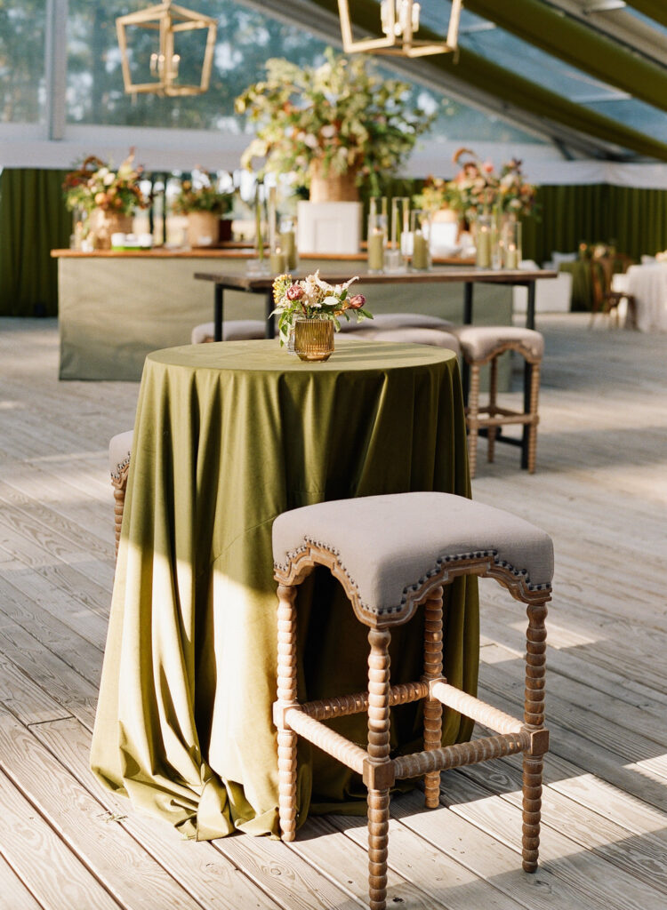 cocktail tables at wedding reception with green velvet linen