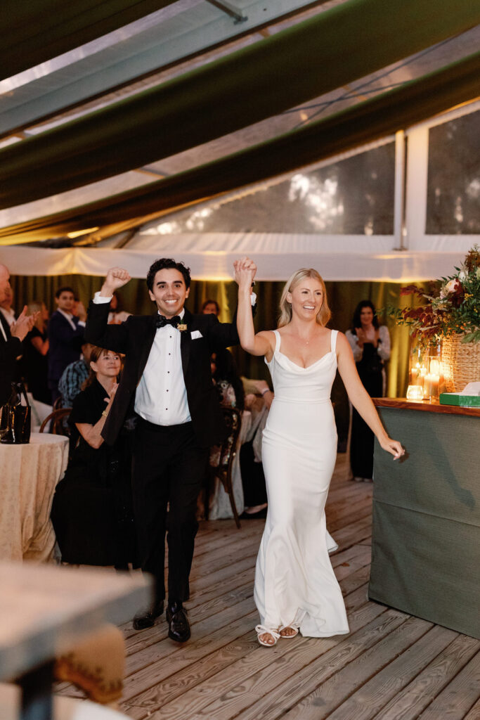 bride and groom entering tented wedding reception