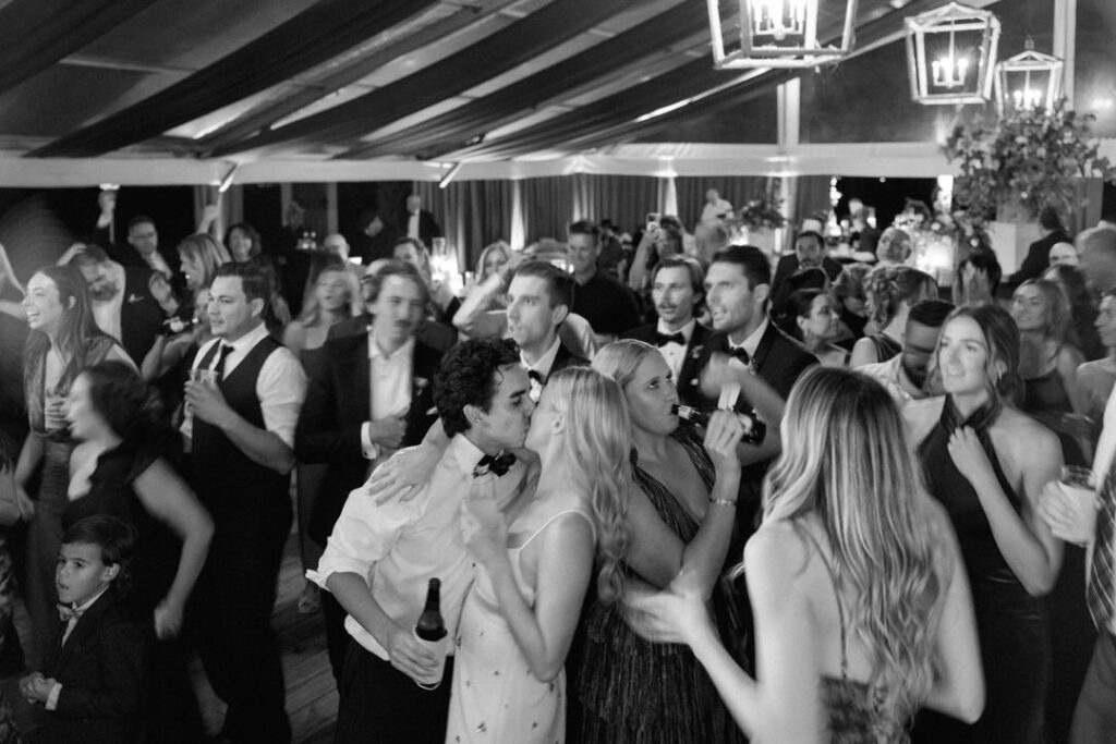 black and white of bride and groom kissing on dance floor